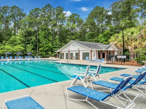 Exterior view of a 3-bedroom townhome with a screened-in patio and wooded views in the Hunt Club community, Pooler, GA.
